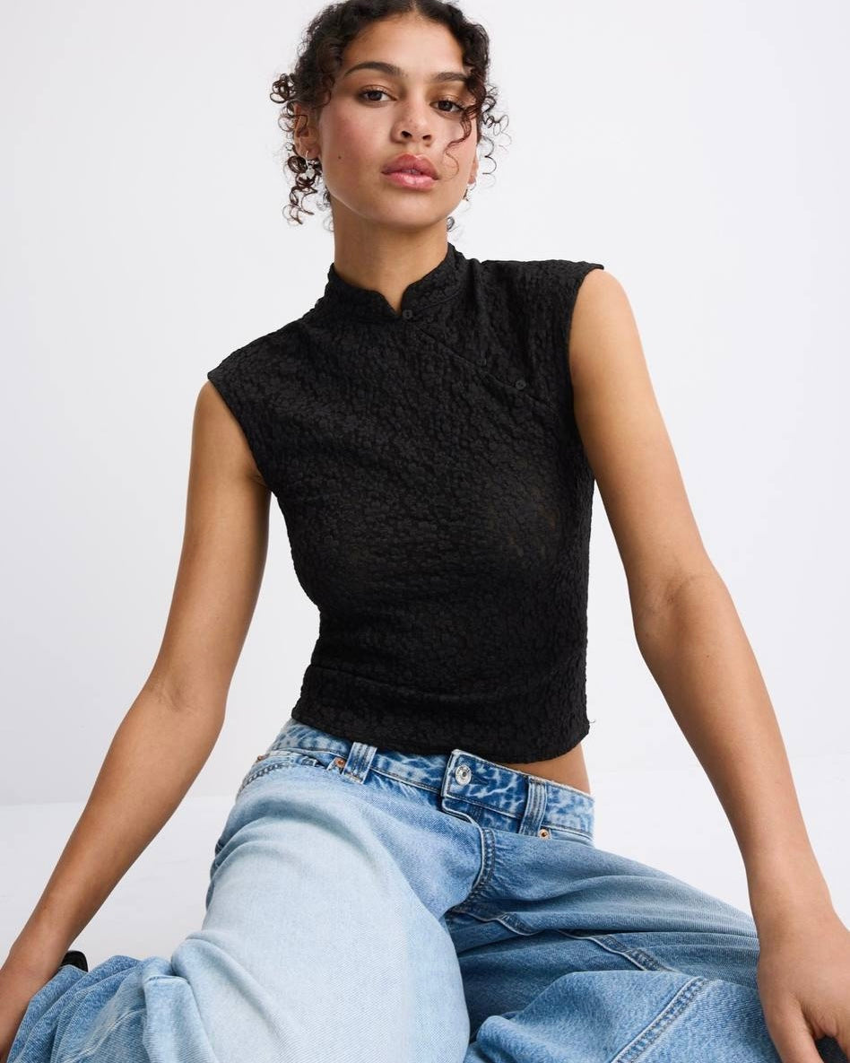 Button Detail Top | بلوزة نسائية سوداء أنيقة بدون أكمام بياقة عالية وقماش محبب شفاف مع ازرار